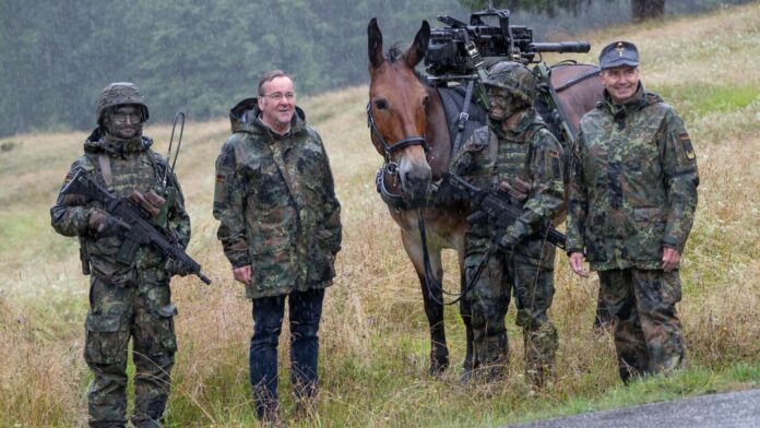 Bundesverteidigungsminister Boris Pistorius im GORE-TEX Nässeschutz im Regen